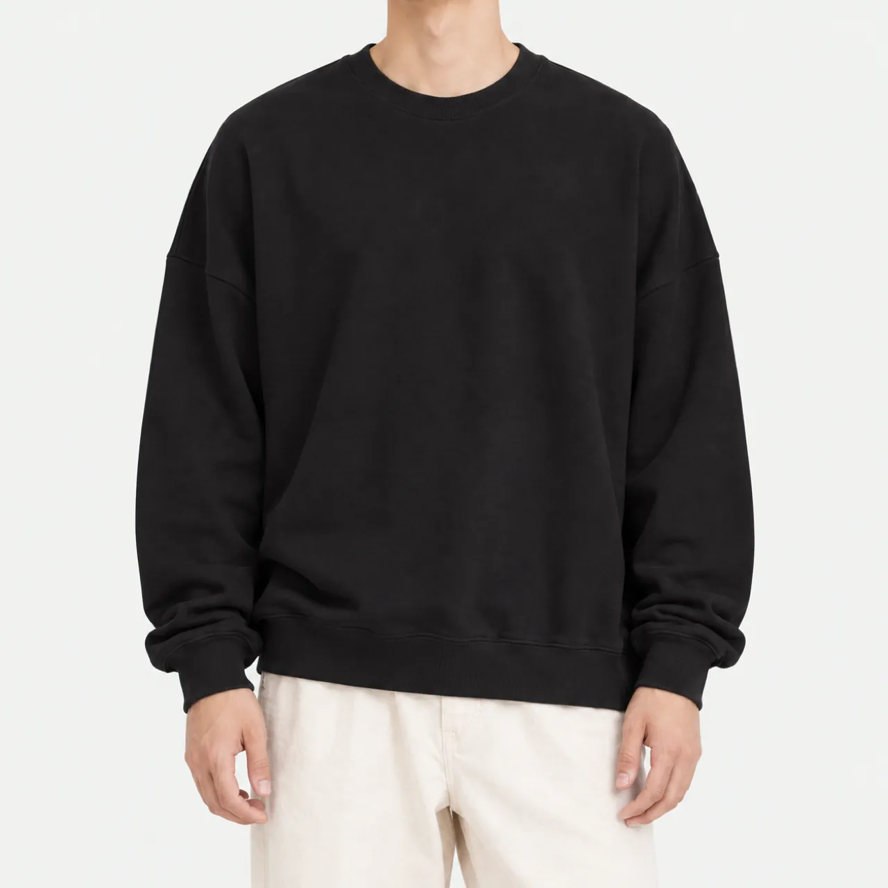 Front view of a model wearing a black oversized terry sweatshirt
