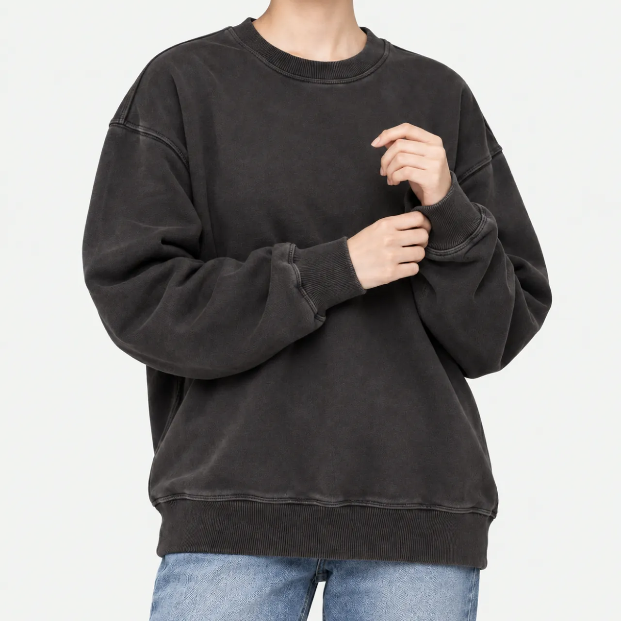 Front view of a model wearing a black pigment-washed sweatshirt