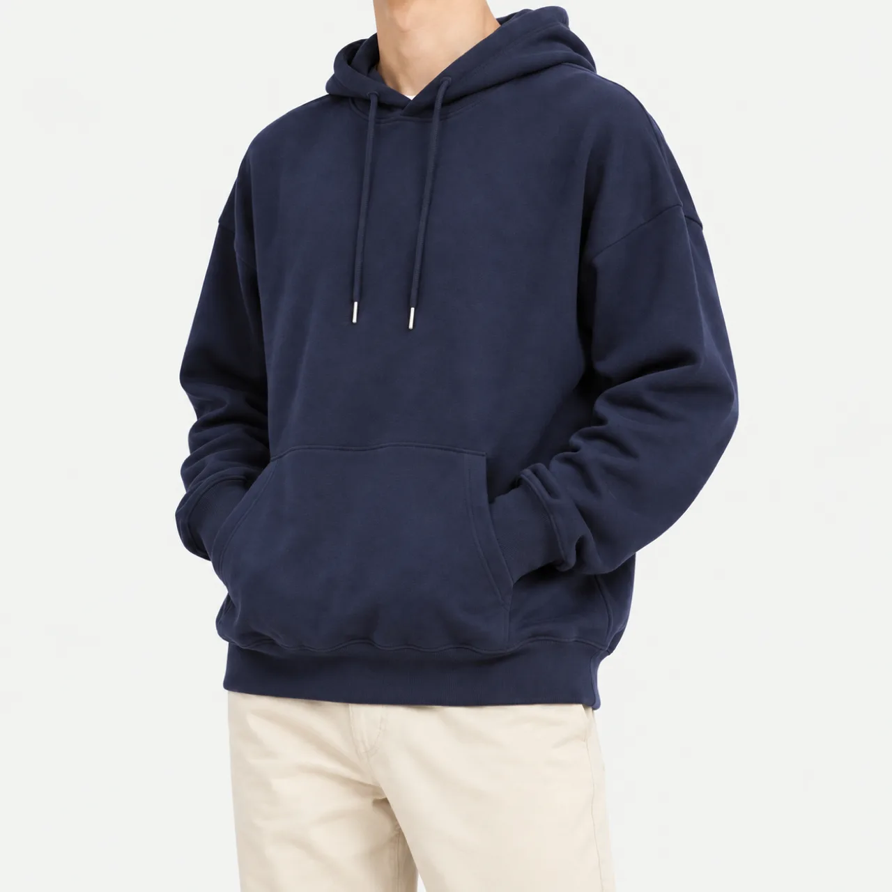 A model wearing a navy oversized light hoodie with hands in the pocket