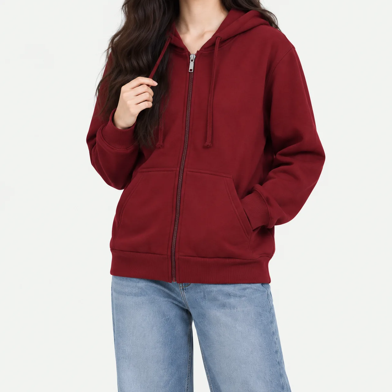 A model wearing a burgundy basic zip-up hoodie with a hand in the pocket