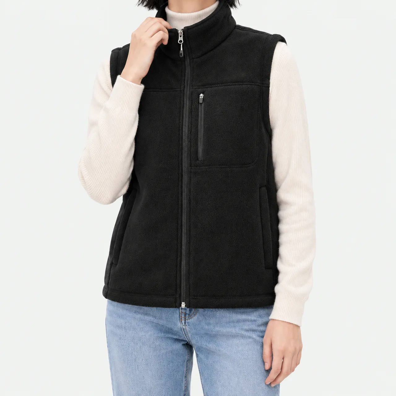 A model wearing a black boa fleece vest and holding the collar