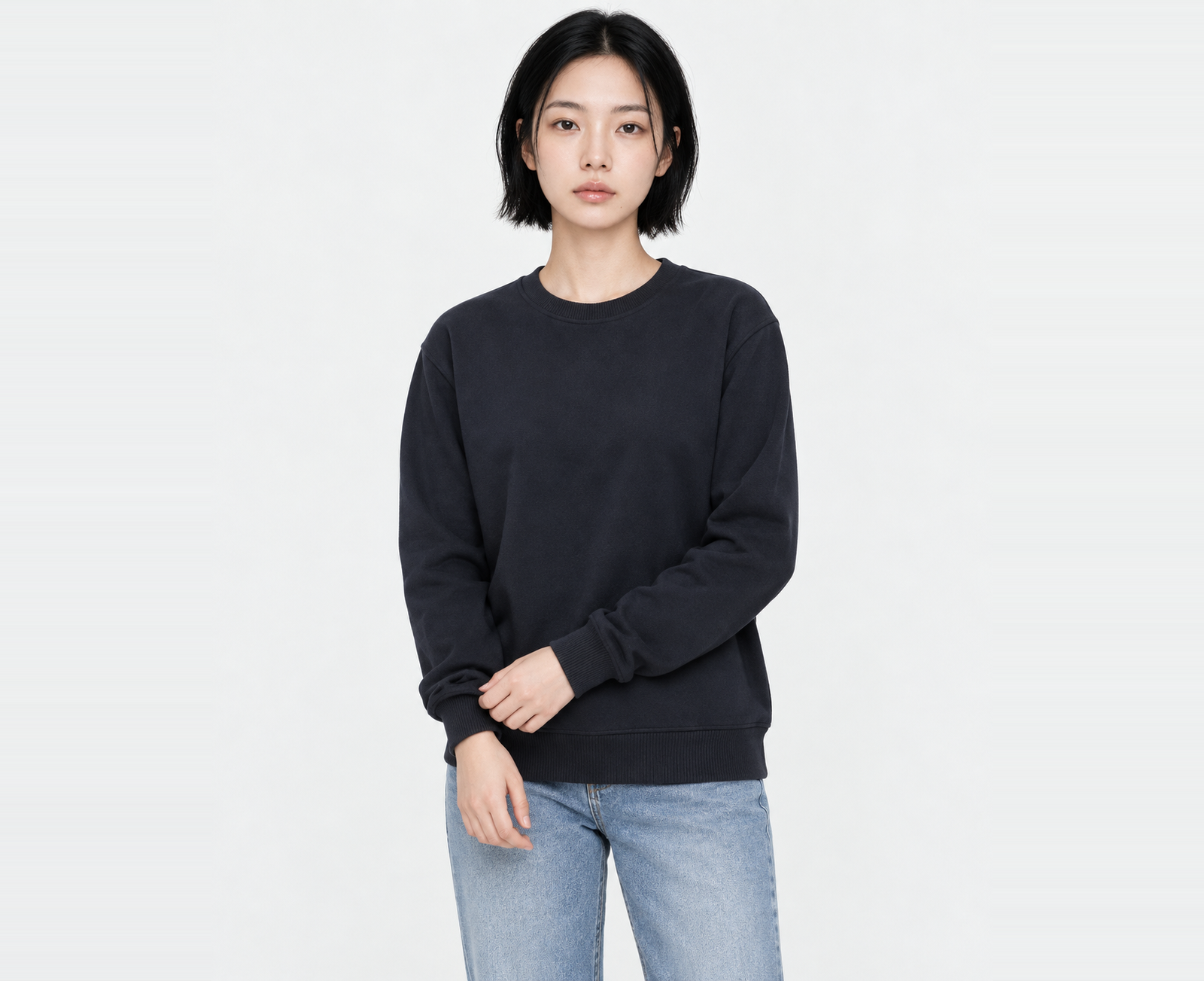 Woman wearing a navy light sweatshirt in L with room to spare, lightly holding one cuff