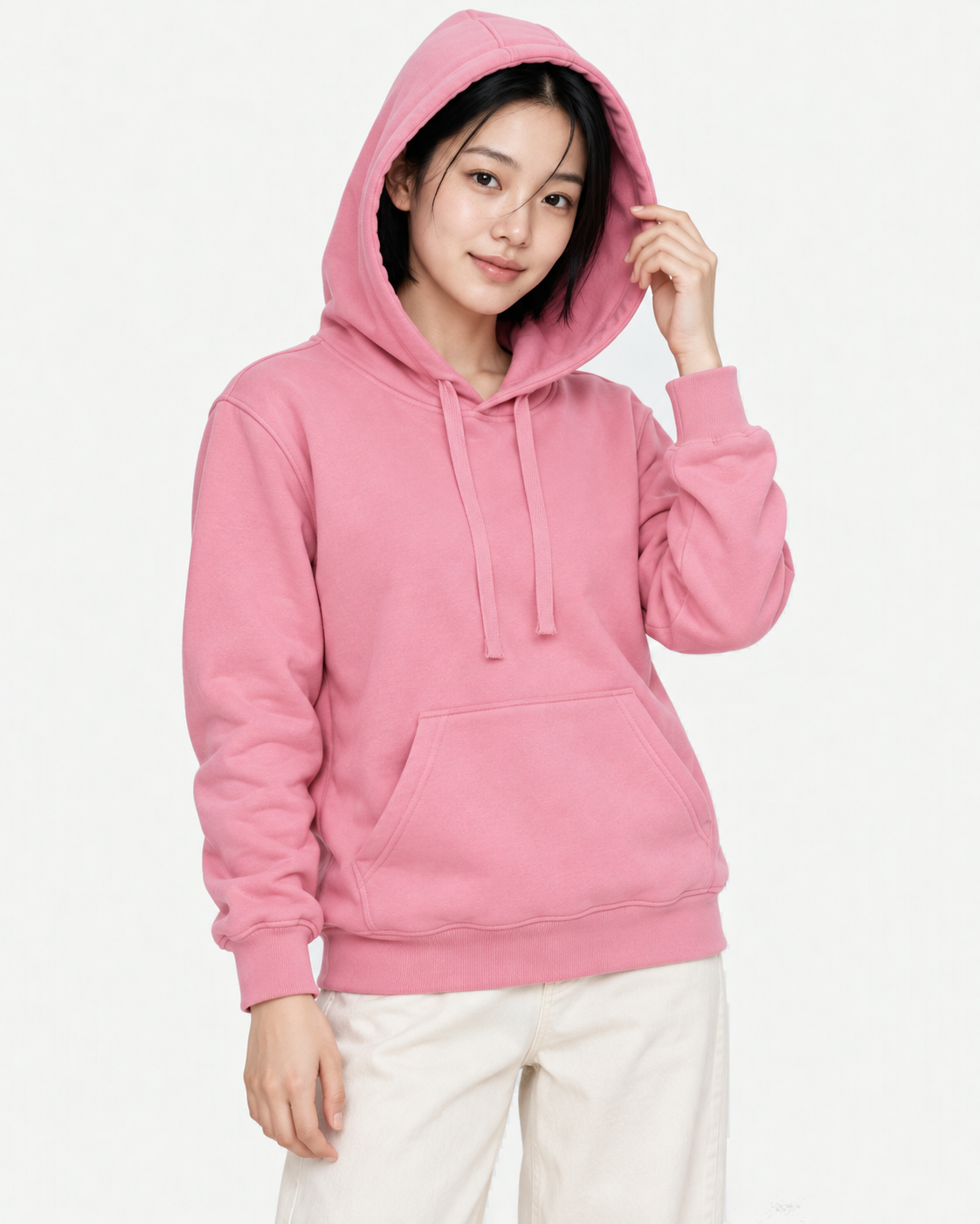 Upper body of a woman wearing the hood of a pink light hoodie in M, holding the hood edge with one hand