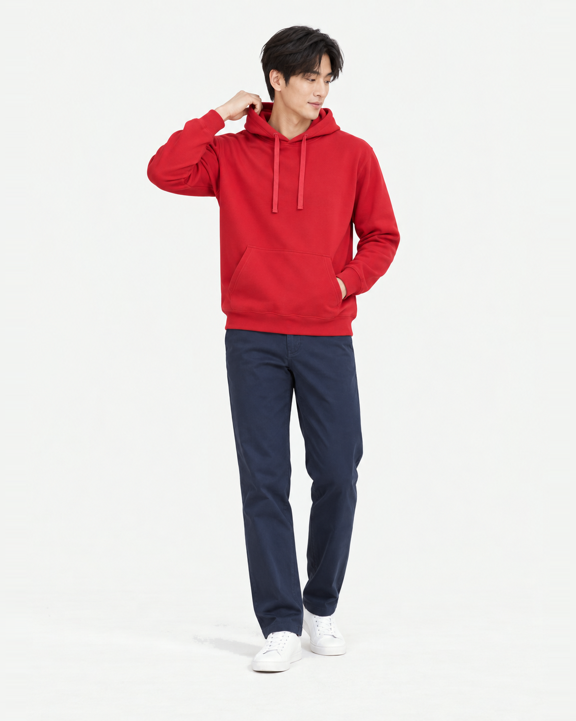 Full-length shot of a man wearing a red light hoodie in L, holding the hood edge behind his neck and looking down to the side