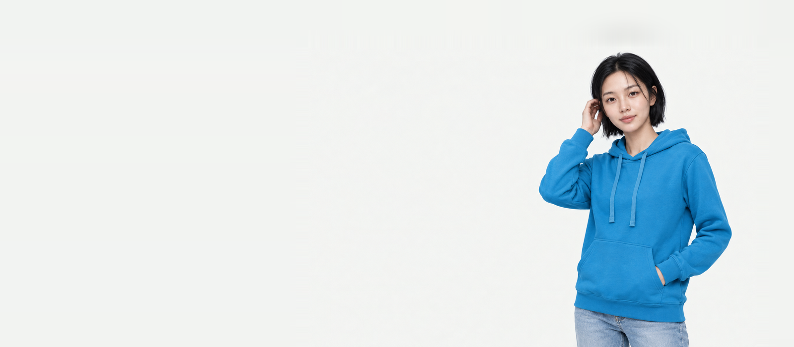 Banner: woman wearing a sky blue light hoodie in M, tucking her hair behind her ear with her right hand