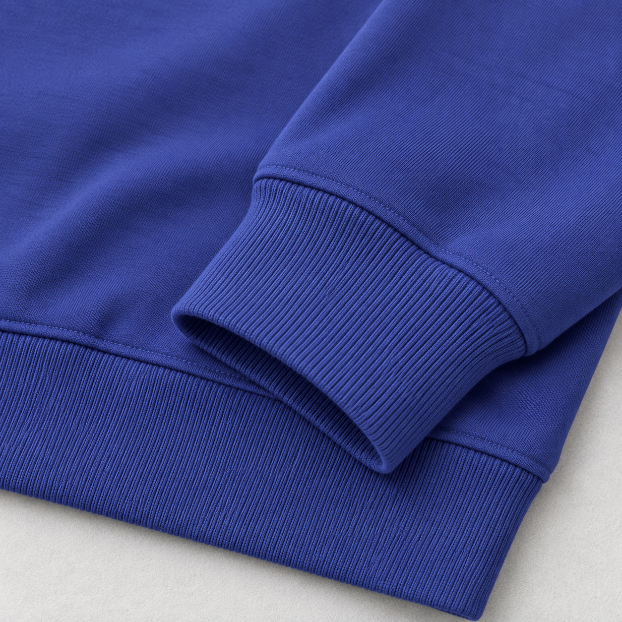 Close-up of the rib cuffs and rib hem on a cobalt blue hoodie
