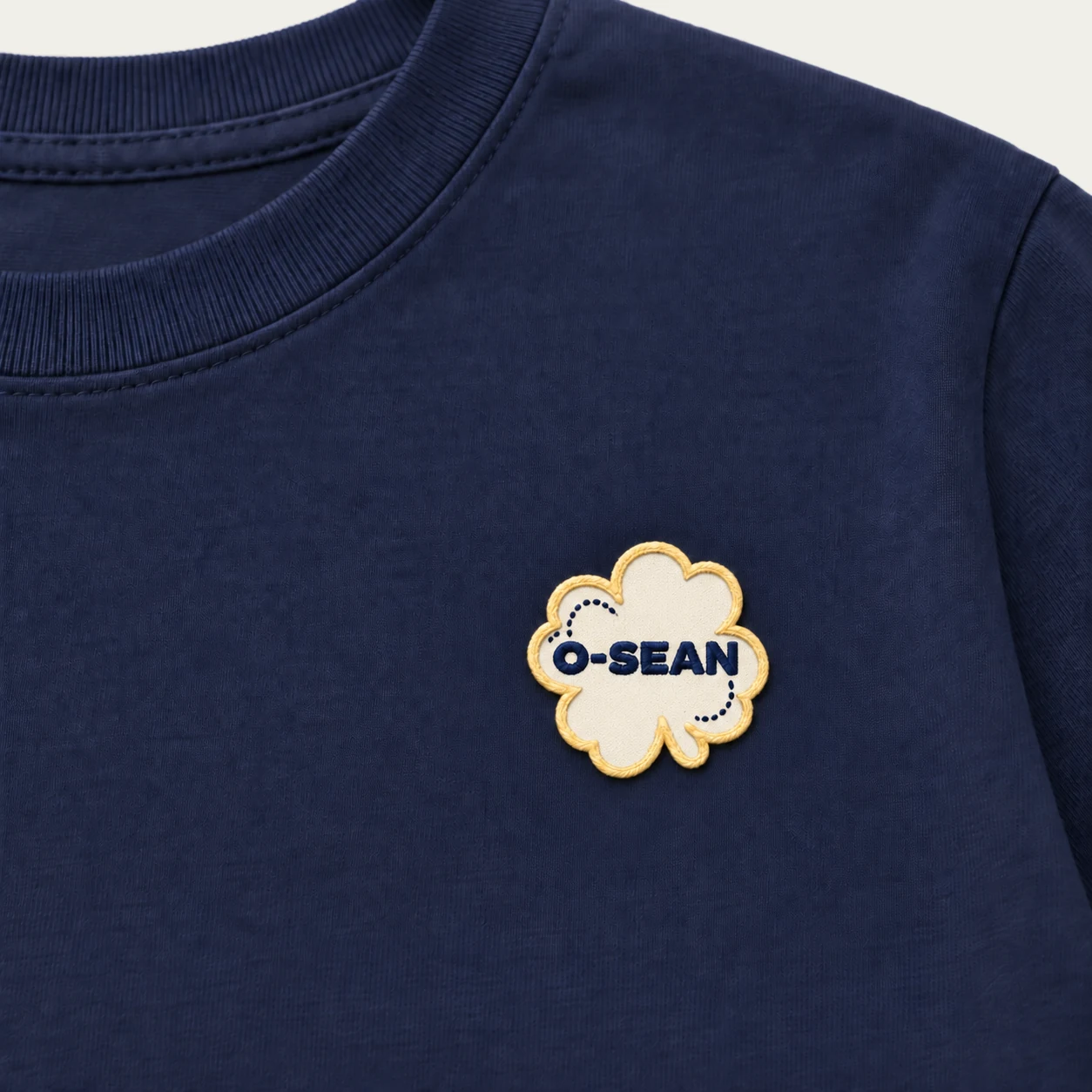 O-SEAN patch sewn on the left chest of a navy short-sleeve T-shirt