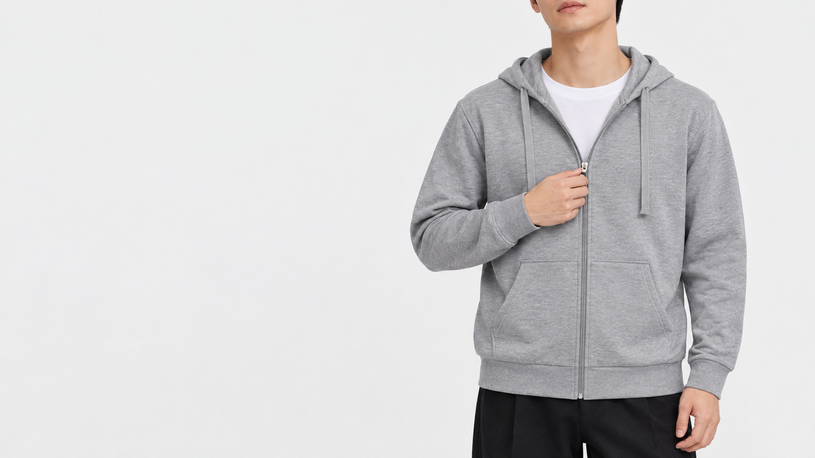 Torso of a man pulling the silver zipper of a Moku gray light zip-up hoodie in L up to his chest