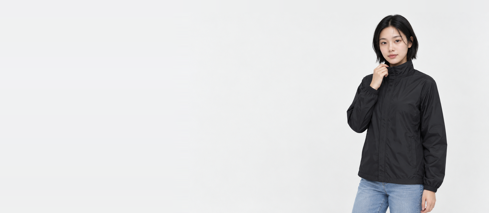 Banner: woman wearing a black basic windbreaker in M, holding the stand collar with one hand