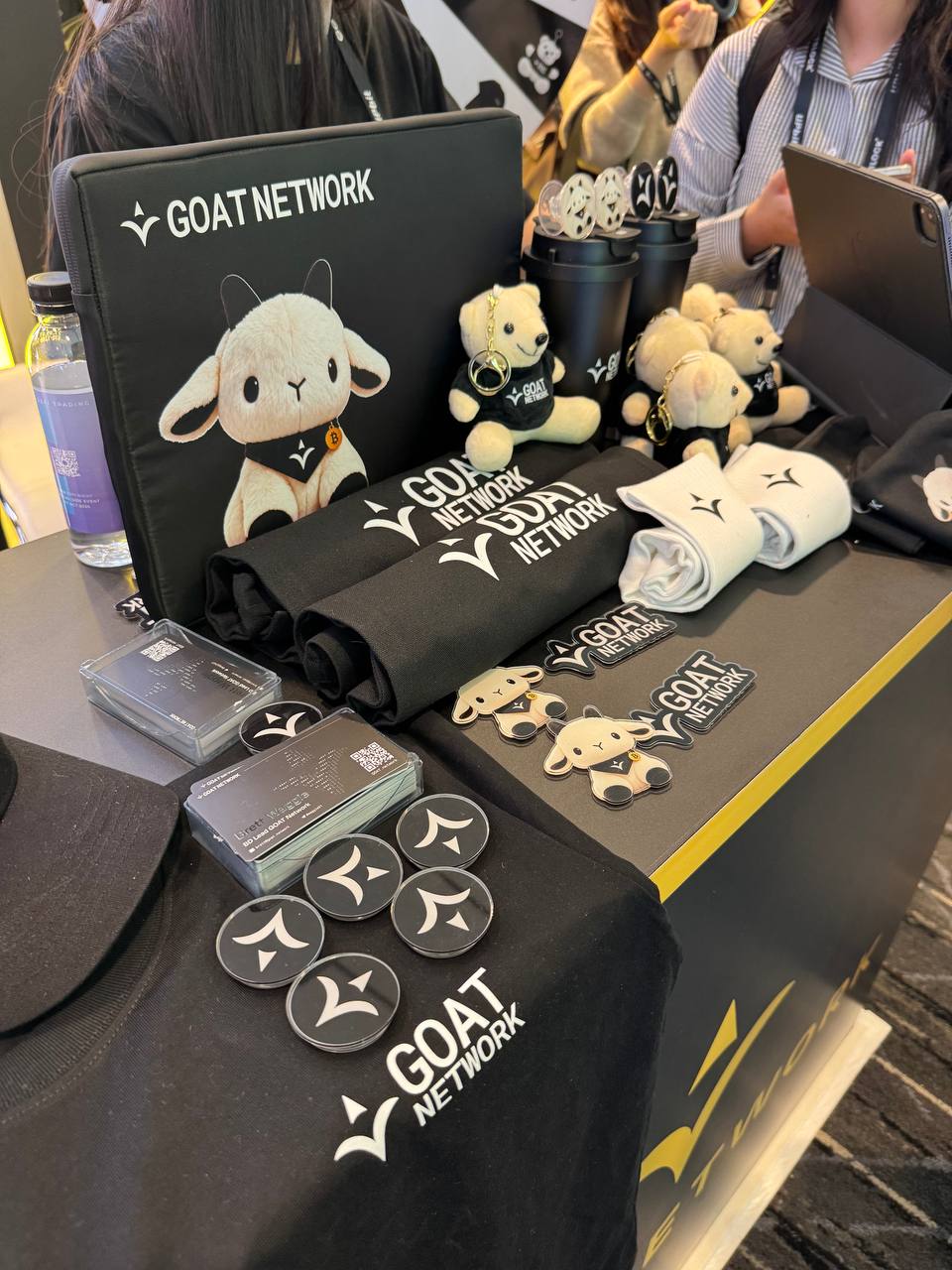 GOAT Network 행사에 진열된 염소 캐릭터 인형과 티셔츠 텀블러 키링